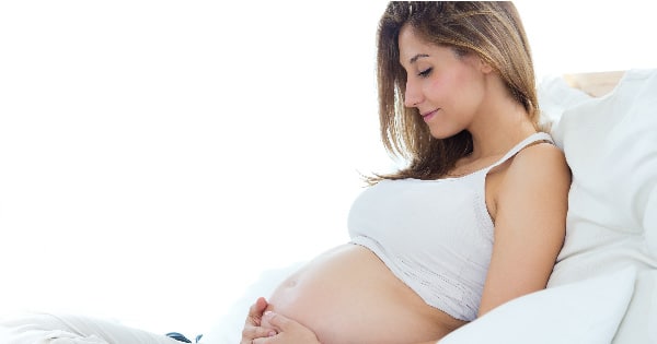 pregnant woman in West Vancouver holding belly and smiling